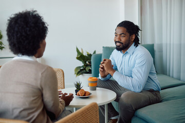 Fototapeta na wymiar Happy black businessman talks to female colleague on coffee break in office.