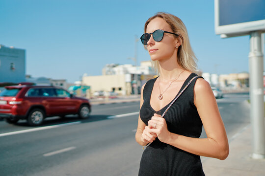 Blond woman in sunglasses outdoors.
