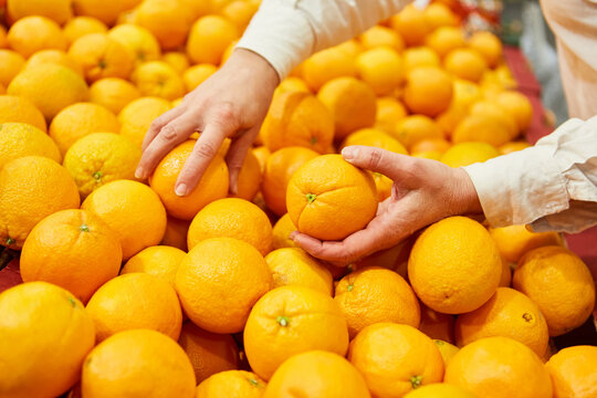 Customer in the supermarket shopping for oranges