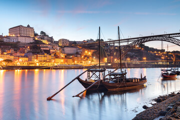 Landscape of the Ribeira district  in Oporto city, Portugal - D Luis I bridge - Rabelo Boats with port wine barrels in the Douro river - Travel and vacation concept
