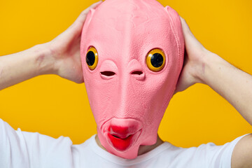 a man in a funny rubber mask grabs his head