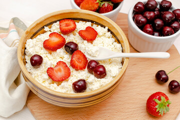 Cottage cheese with summer strawberries cherry berries.curd cheese in bowl with honey.Healthy dairy Calcium,Protein product,food breakfast,lunch,lifestyle,dieting, detox,proper nutrition.Top view