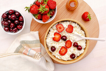Cottage cheese with summer strawberries cherry berries.curd cheese in bowl with honey.Healthy dairy Calcium,Protein product,food breakfast,lunch,lifestyle,dieting, detox,proper nutrition.Top view