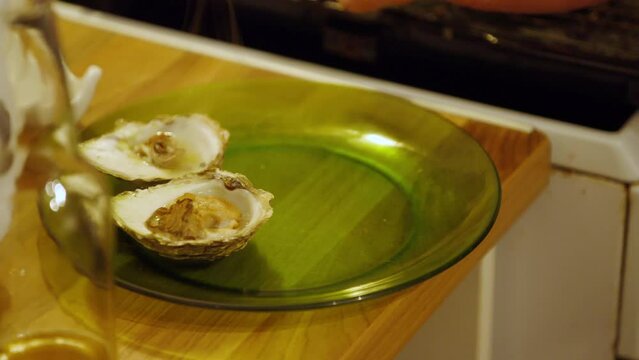 Serving fresh cooked oysters smothered in garlic and butter, wide shot