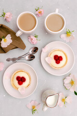 Delicious red raspberry strawberry whipped creamy tartlets,cakes.gourmet confection dessert on plate with latte coffee,milk.sweet tasty pastry baked pie cheesecake with ripe berries on gray table