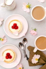 Delicious red raspberry strawberry whipped creamy tartlets,cakes.gourmet confection dessert on plate with latte coffee,milk.sweet tasty pastry baked pie cheesecake with ripe berries on gray table