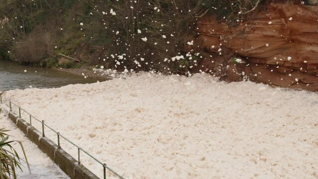 Sea foam cappuccino coloured swirls in wind coast Sidmouth south west England