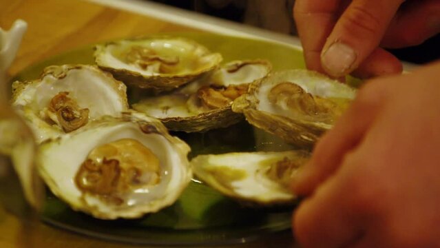 Serving fresh cooked oysters smothered in garlic and butter, close shot