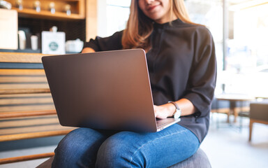 Closeup image of a businesswoman working on laptop computer in cafe