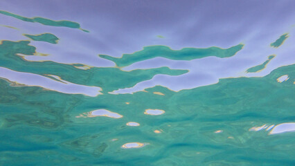 Fototapeta na wymiar Surface of the sea. Natural background with sun glints on surface of the water. Underwater view. Red sea, Egypt
