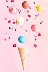 Falling ice cream scoops and berries into the vafel cone