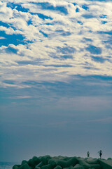 방파제 끝에서 바다 풍경을 찍는 사진사