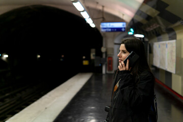 Young woman talking on the phone in the paris subway