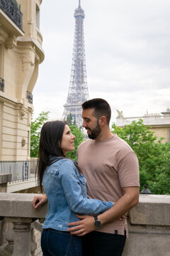 Couple in love gazing into each other's eyes with the eiffel tower in the background.