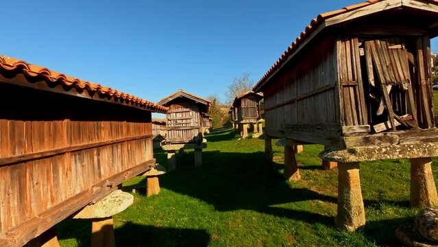 Dolly in between set of wooden Spanish granaries in A Merca, Galicia, Spain
