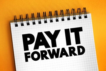 PAY IT FORWARD text on notepad, concept background