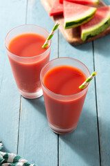 Fresh watermelon juice in glass on blue wooden table