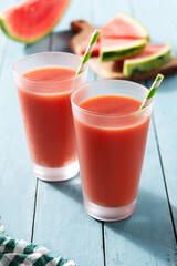 Fresh watermelon juice in glass on blue wooden table