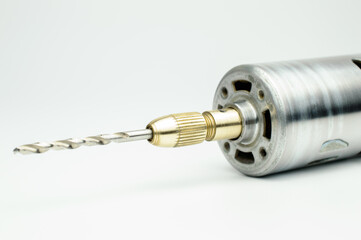 Electric micro drill for drilling of printed circuit boards (PCB). Small drilling machine made of steel. DC brushed motor. Selective focus. Isolated on white background.