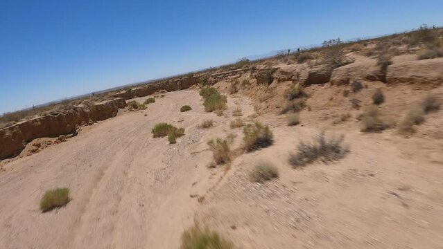 Flying through an arroyo in the Mojave Desert's arid landscape in a first-person drone