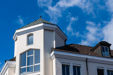 The top of the building with a turret against the blue sky.