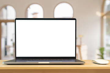 Laptop with blank screen on wood table with cafe coffee shop blur background