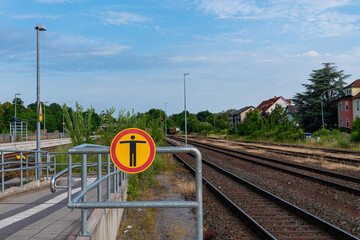 No trespassing sign on a train station with rail roads.