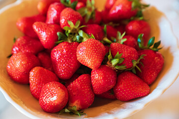 ripe and fresh strawberries in a white plate. healthy and delicious dessert. natural farm products. seasonal berry.