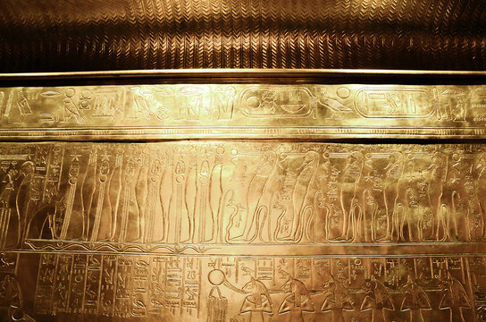 A golden wall with engraved Egyptian symbols, the tomb of pharaoh Tutankhamun