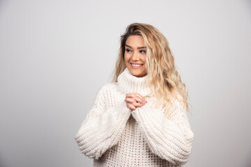 Blonde woman in winter outfit smiling happily