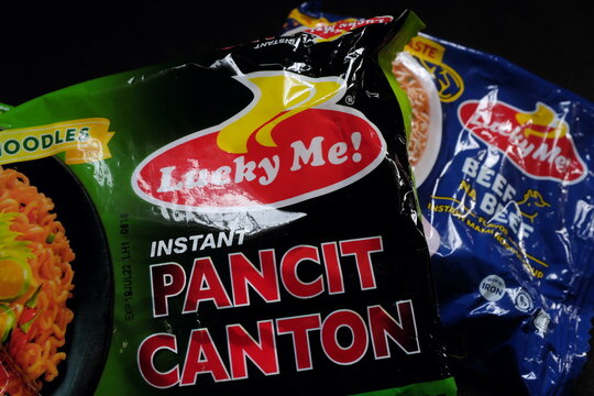 Manila, Philippines - July 07, 2022 : Product shot of Monde Nissin Lucky Me Instant noodles pancit canton Chilimansi flavor and beef soup in dark black background.