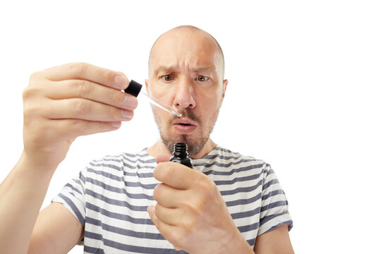 Close up image of  bearded man with pipette with beard oil on white background.