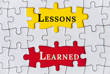 Top view of lessons learned text on Jigsaw Puzzle. Improvement concept