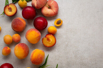 Fresh nectarine peaches plum fruits on ligt surface copy space top