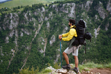 Naklejka premium Sports, success and achievement concept. Young hiker, happy with that he successfully achieved top