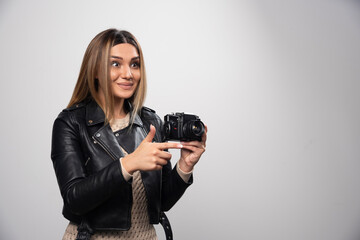 Girl in leather jacket taking her photos in funny and strange positions