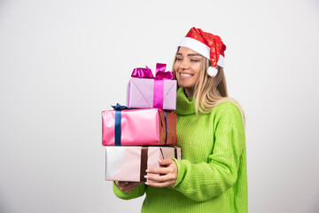 Young woman holding a lot of festive Christmas presents