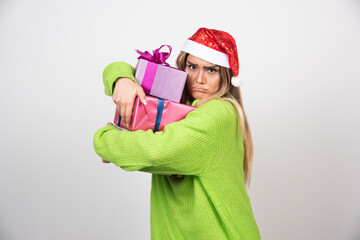 Young woman holding a lot of festive Christmas presents