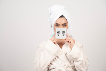 Portrait of woman in white towel with eye shadow palette