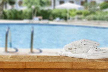 Desk with towels and swimming pool  background. 