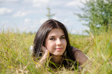 Portrait of young attractive woman. Young woman lying in the grass