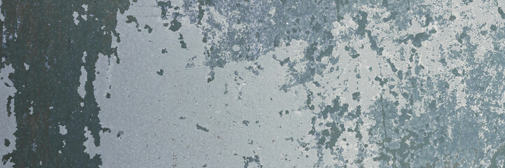 Peeling paint on the wall. Panorama of a concrete wall with old cracked flaking paint. Weathered rough painted surface with patterns of cracks and peeling. Wide panoramic texture for design background