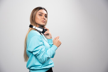 Blonde girl in blue sweatshirt posing with headphones