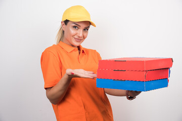 Blonde delivery woman holding pizza boxes on white background