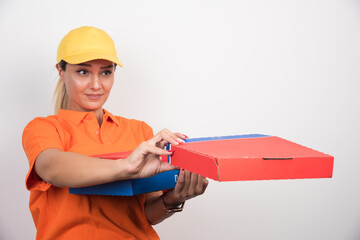 Pizza delivery woman giving away pizza boxes on white background