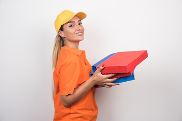 Pizza delivery woman holding pizza boxes with peaceful face on white background