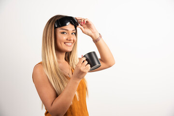 Obraz premium Young woman holding black cup and wearing goggles
