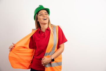 Smiling woman in protective uniform and helmet posing on white background
