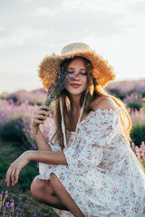 portrait of a young blonde girl in a lavender field in the summer at sunset