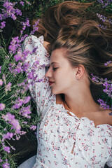 portrait of a young girl sleeping in a blooming lavender field in summer